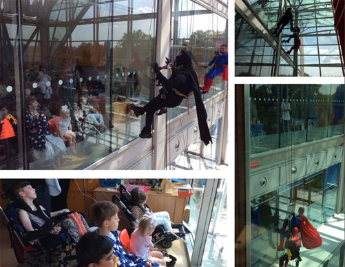 Window cleaner dressed in superhero costumes at Evelina London