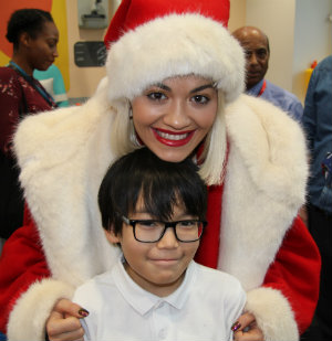 Rita Ora wearing a santa hat with Munkh at Chritmas in Evelina London hospital