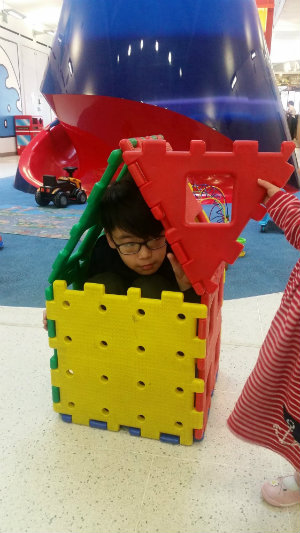 Munkh playing inside a tiny toy house
